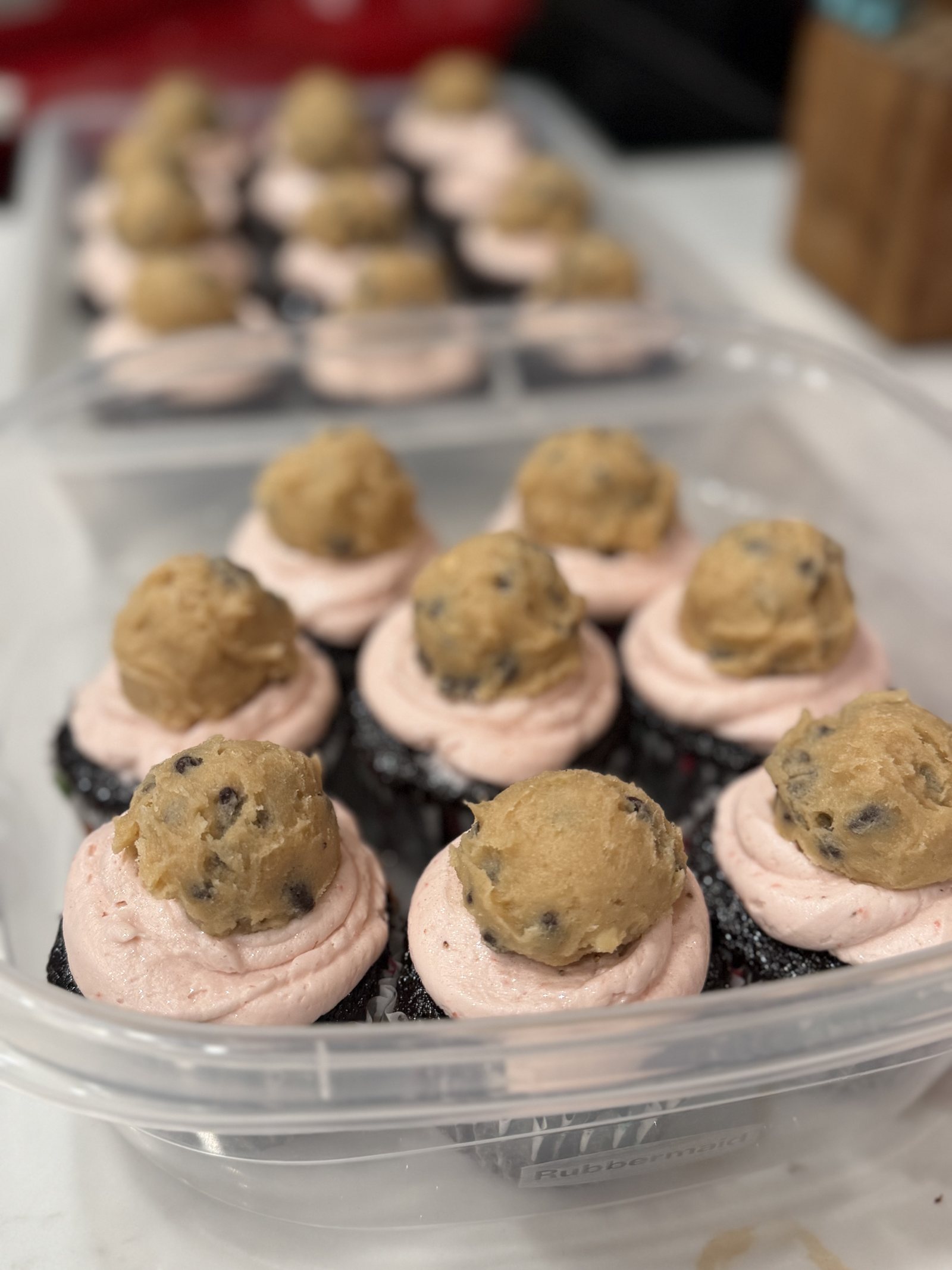 Chocolate cupcakes with pink frosting and cookie dough scoops
